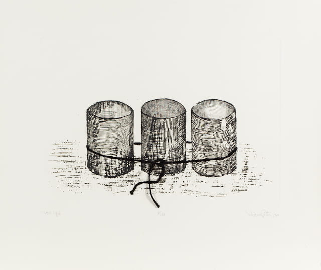 A print of three cylinders that appear to be tied together with a black string attached to the paper.