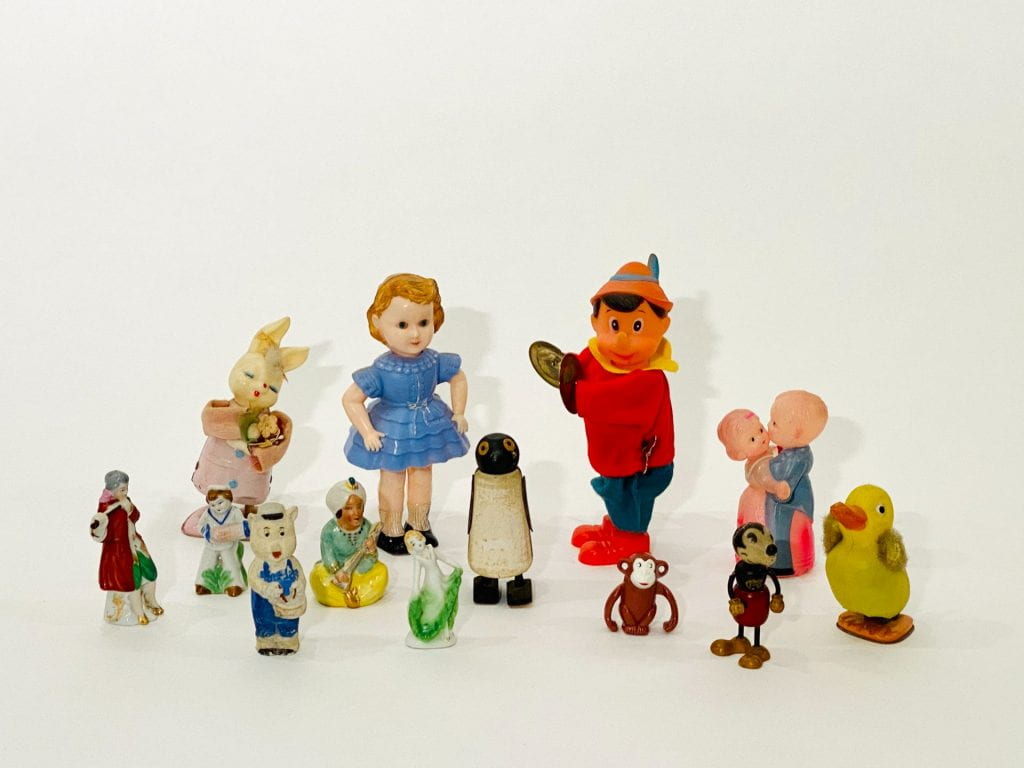 A group of thirteen toy figurines against a white background. 